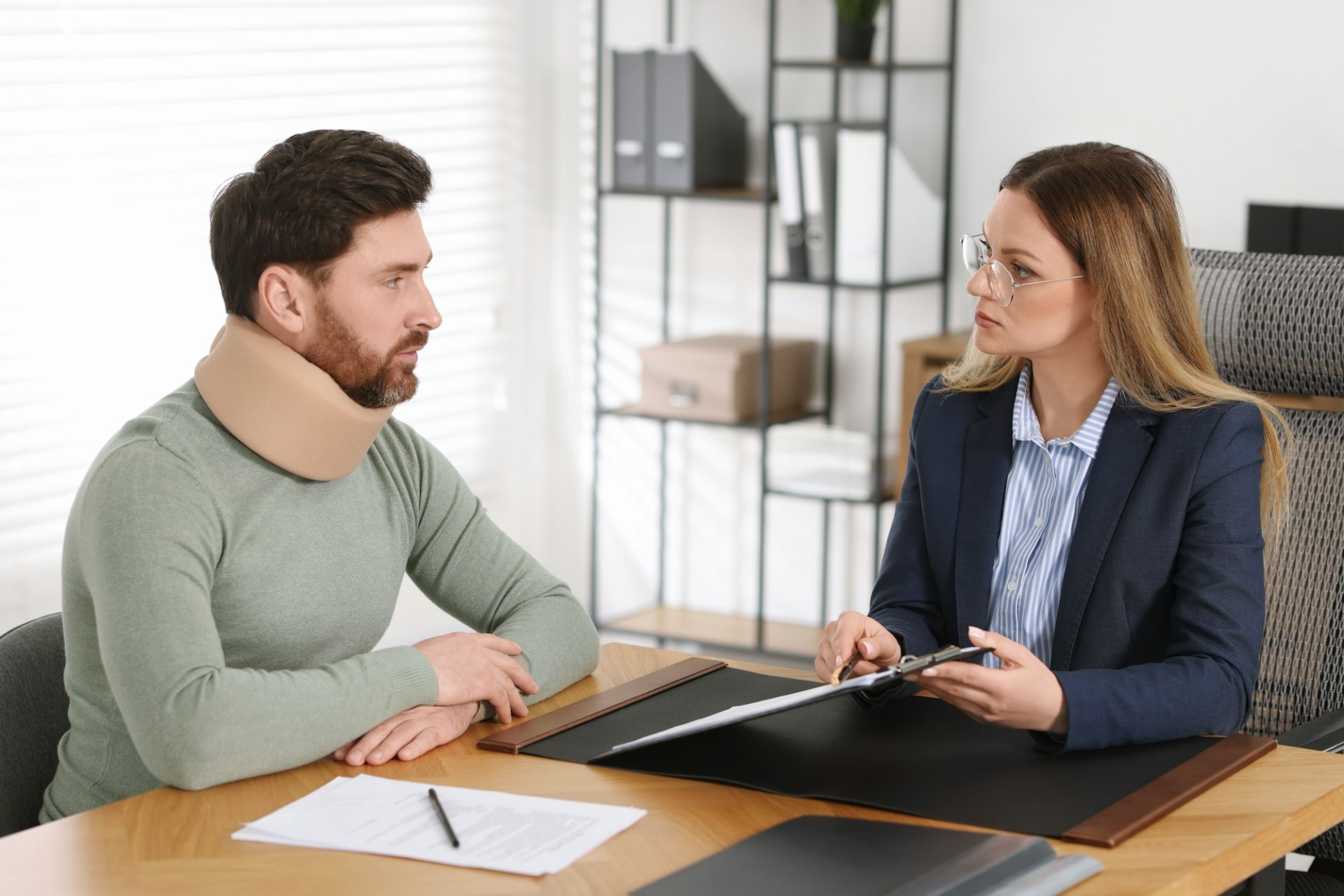 Injured man consulting with a Best Personal Injury Lawyer in Las Vegas, discussing legal paperwork after a car accident.