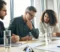 Personal injury lawyers in a strategy meeting discussing a client’s legal case and compensation options in a modern office setting.