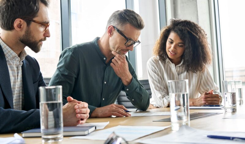 Personal injury lawyers in a strategy meeting discussing a client’s legal case and compensation options in a modern office setting.