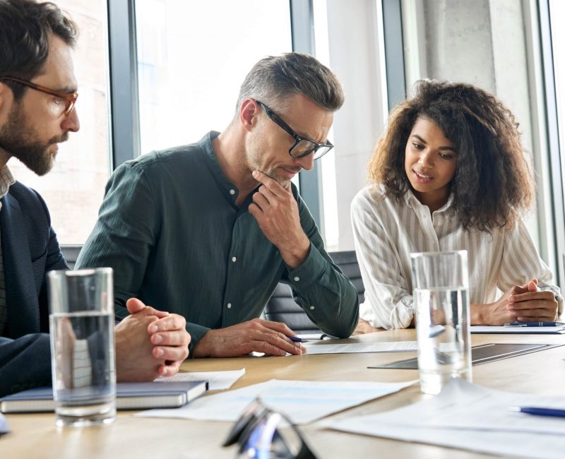 Personal injury lawyers in a strategy meeting discussing a client’s legal case and compensation options in a modern office setting.