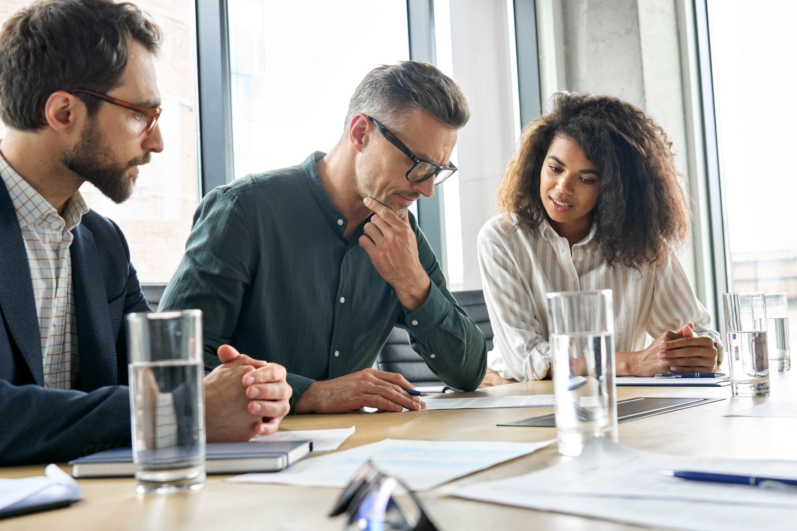 Personal injury lawyers in a strategy meeting discussing a client’s legal case and compensation options in a modern office setting.