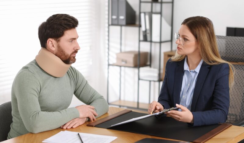 Injured man consulting with a Best Personal Injury Lawyer in Las Vegas, discussing legal paperwork after an accident.
