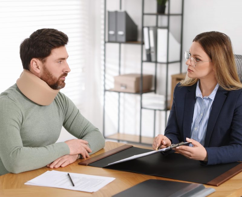 Injured man consulting with a Best Personal Injury Lawyer in Las Vegas, discussing legal paperwork after an accident.
