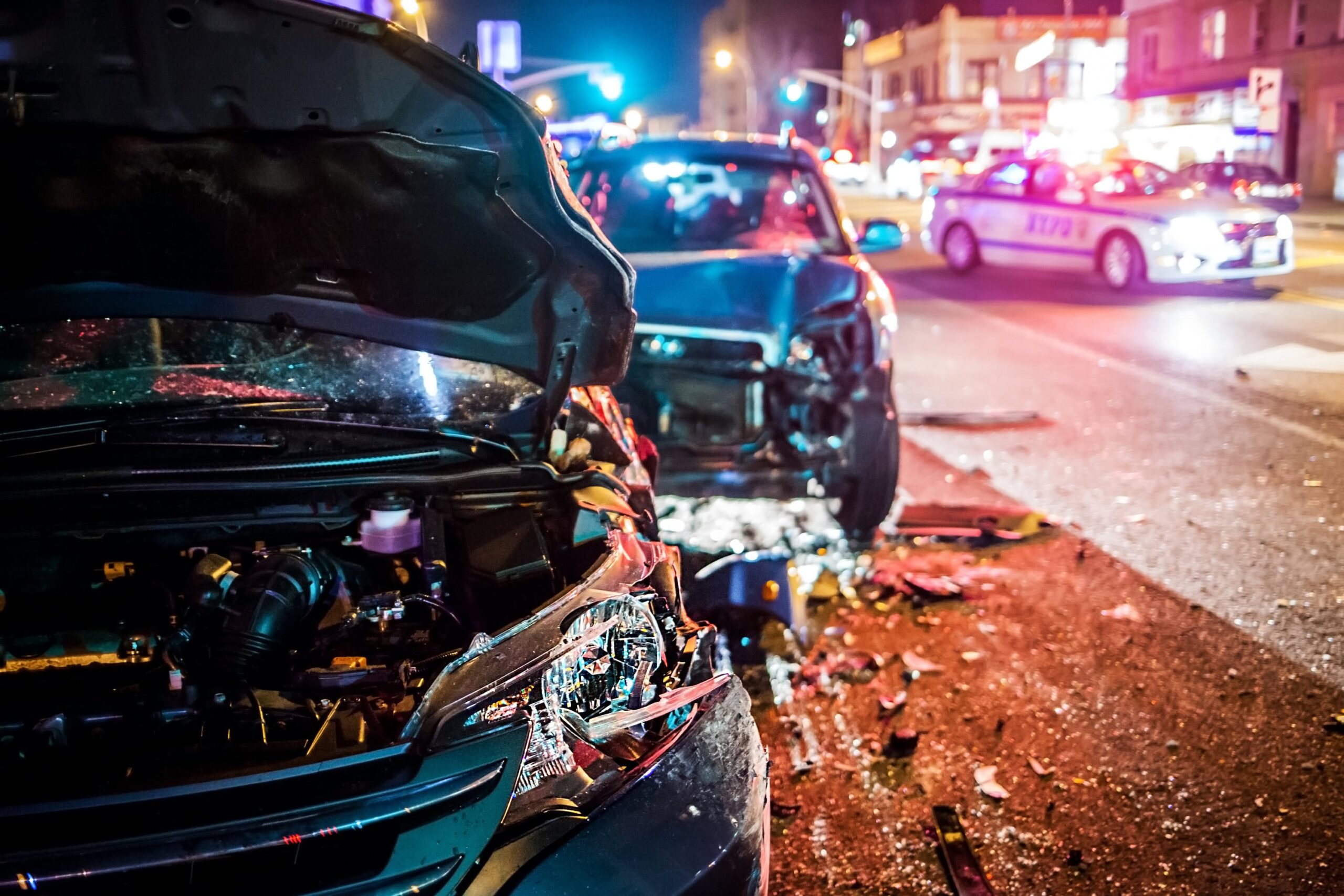 Close-up of a nighttime collision scene with two severely damaged vehicles and police presence, representing the urgency of hiring a car accident attorney.