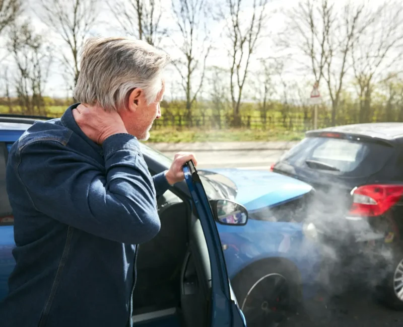 Driver holding neck after crash, signs of whiplash and injury that needs legal help from a car accident lawyer in Las Vegas.